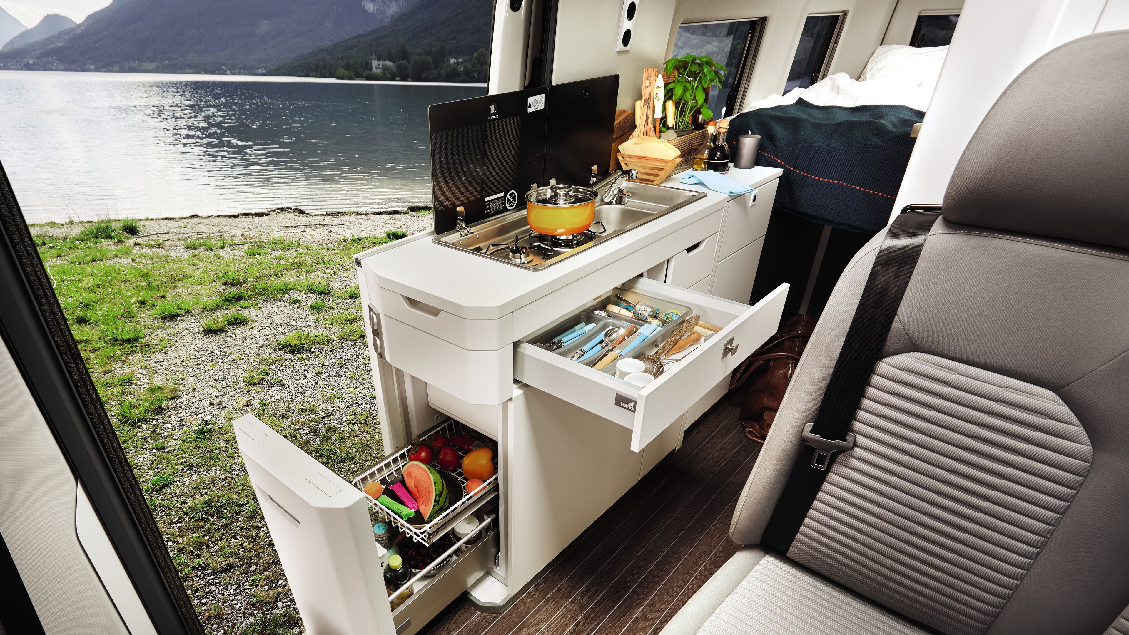 A espaçosa cozinha na VW Grand California pode ser vista. As superfícies estão abertas. 