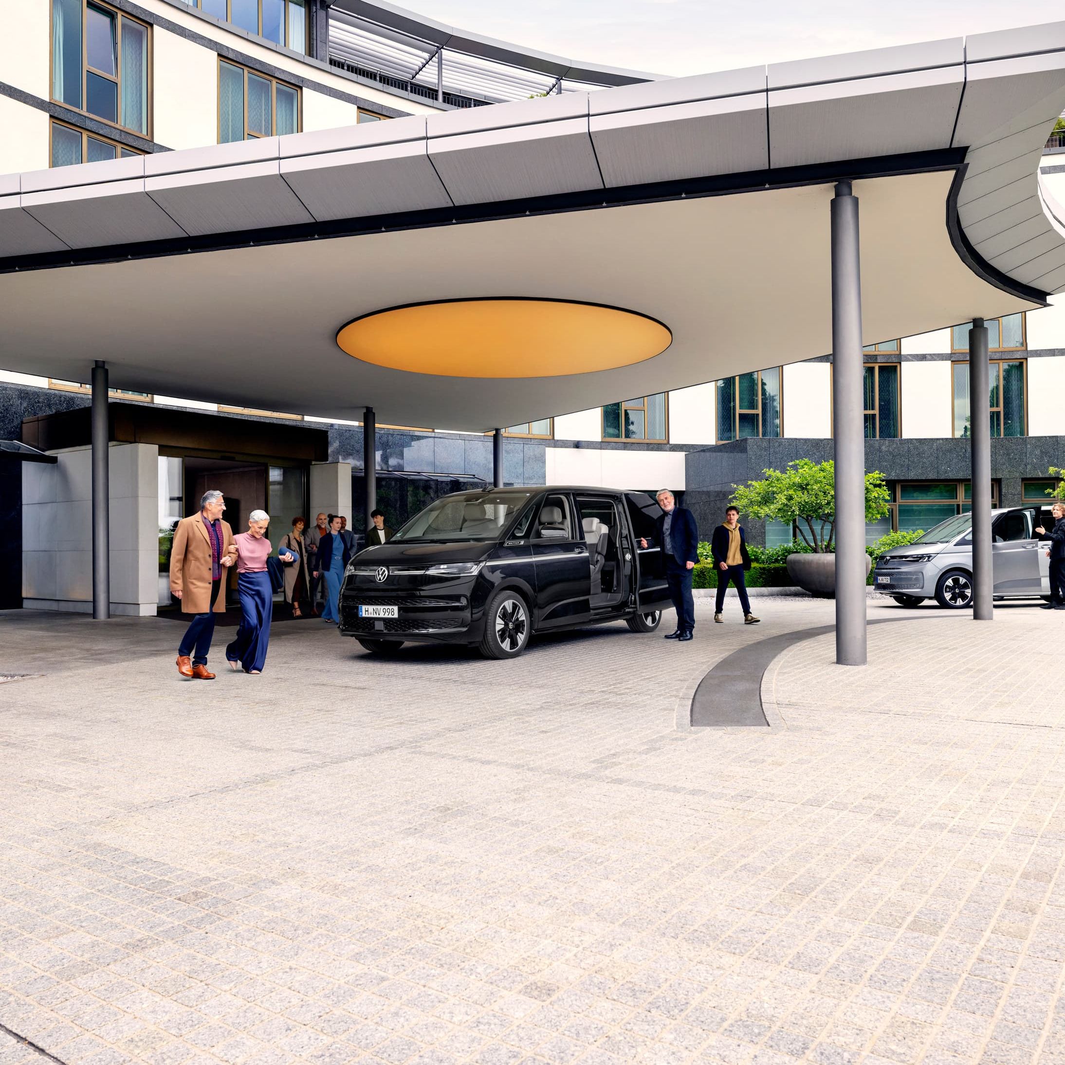 Várias pessoas à volta de uma Volkswagen Multivan 8 lugares