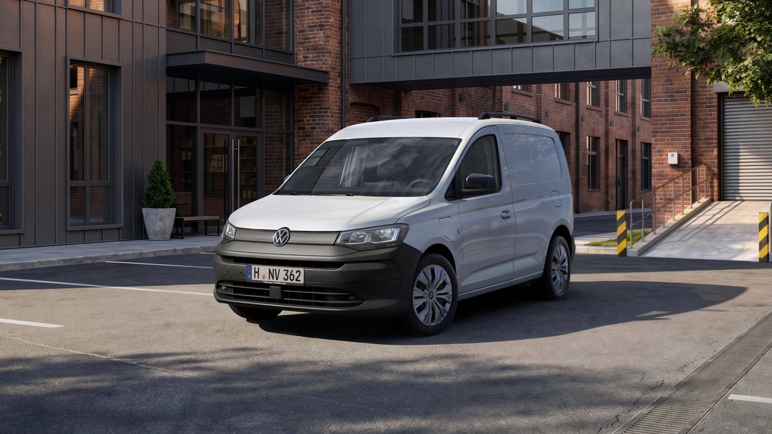 Um Volkswagen Caddy Cargo estacionada à frente de prédios.