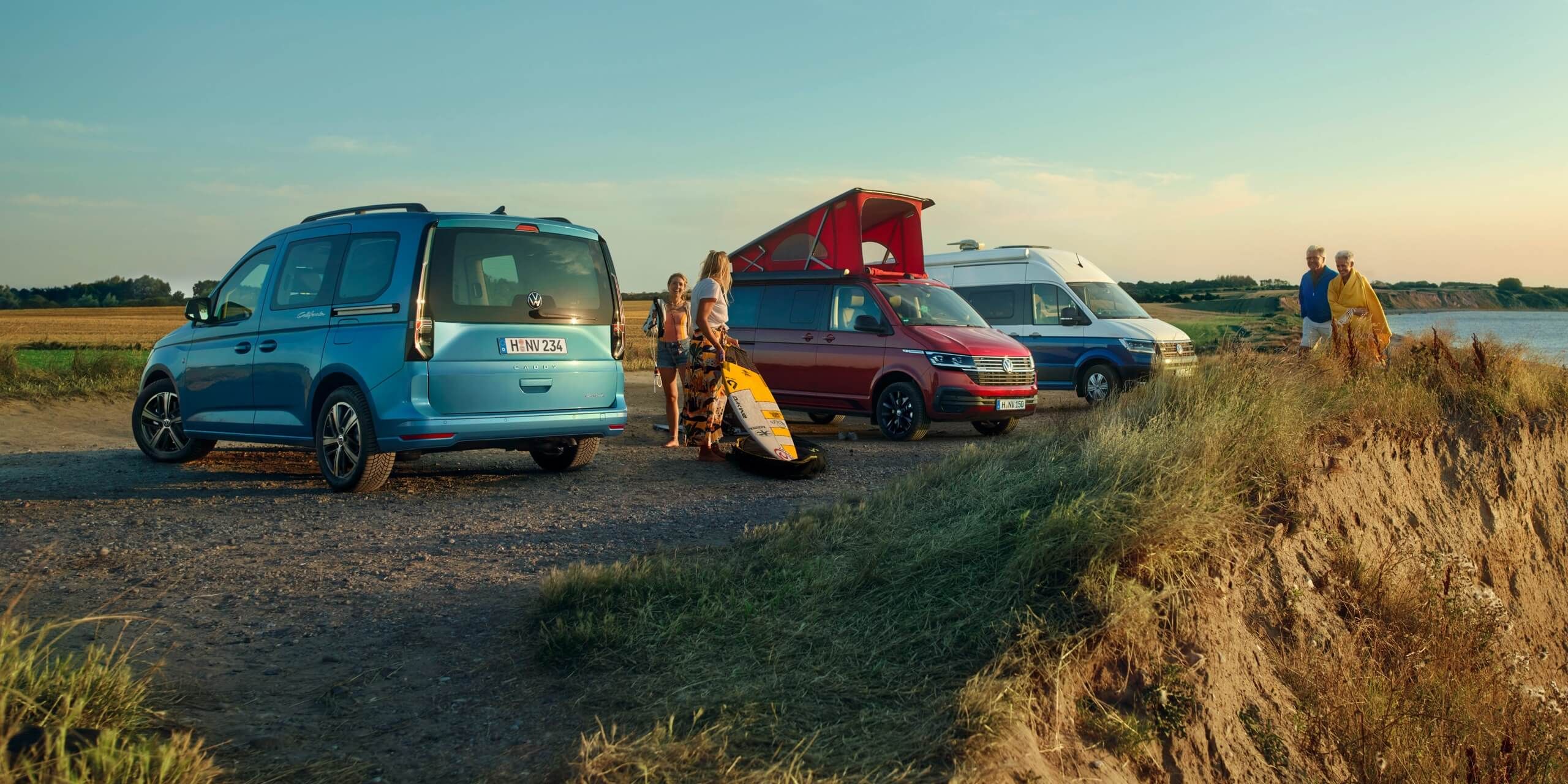 Uma VW Caddy California, uma VW California 6.1 e uma VW Grand California, lado a lado numa duna.