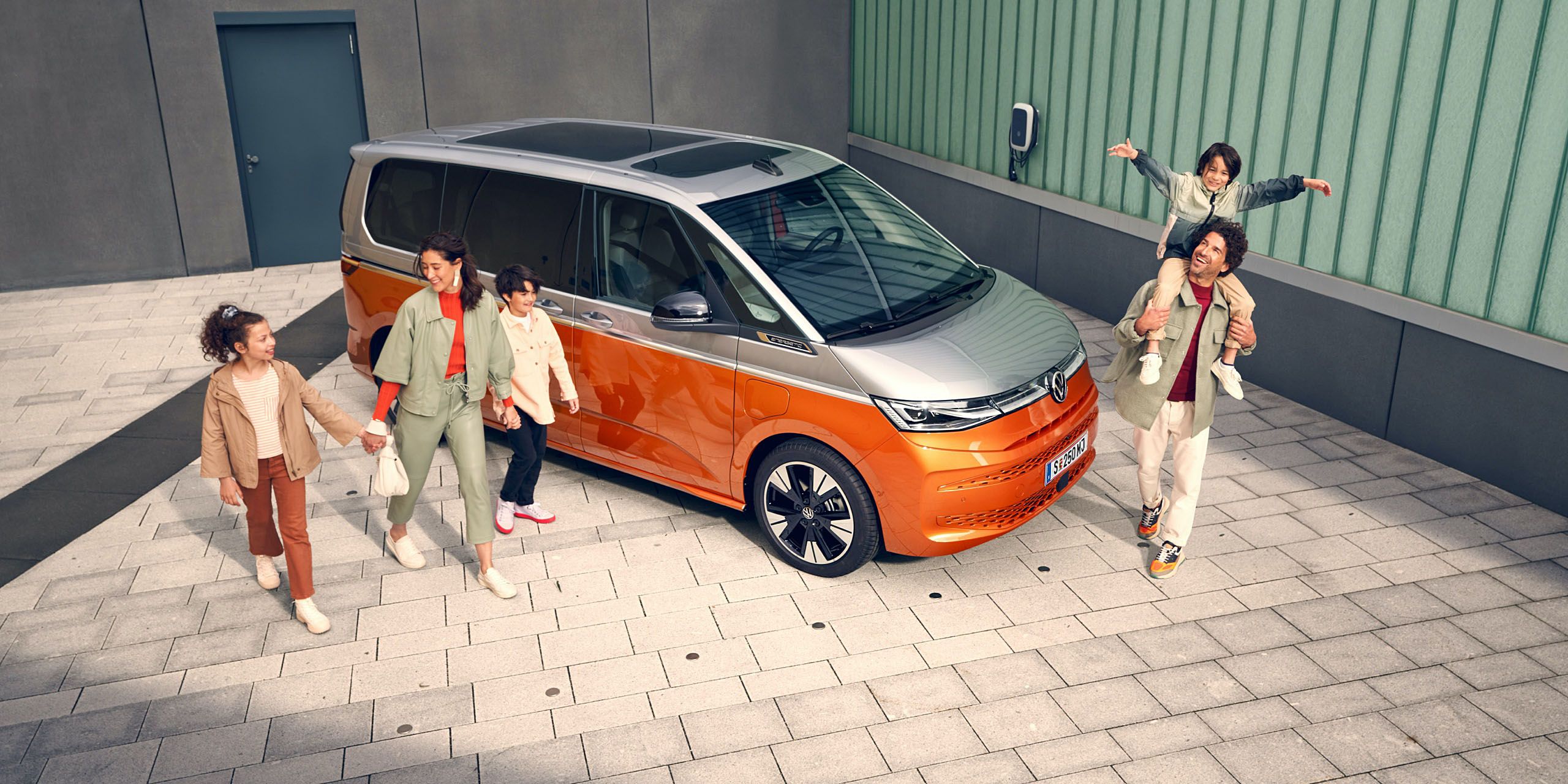 Weißer VW Transporter parkt vor einem Haus