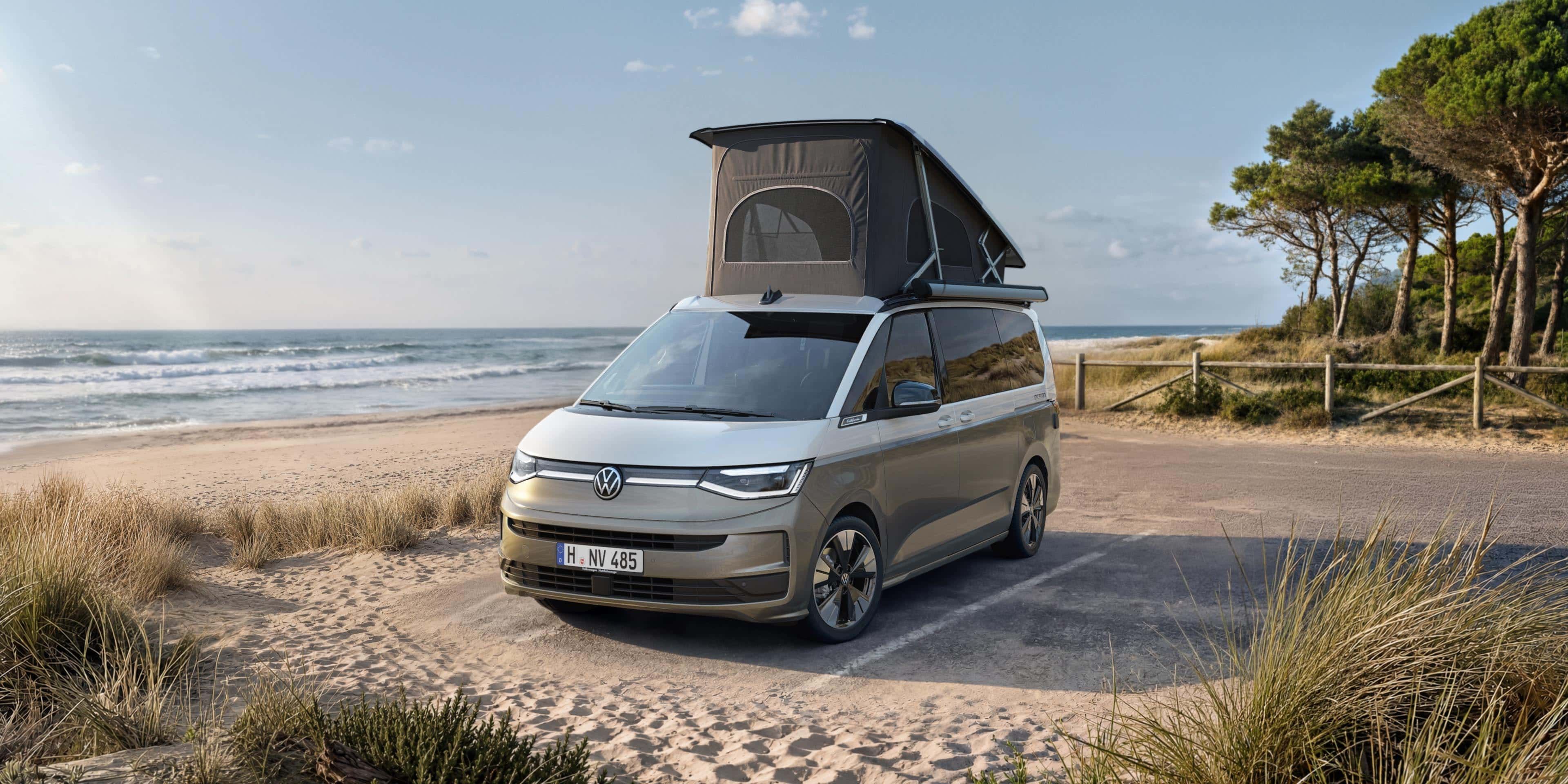 VW California com teto elevatório parada num estacionamento na praia.