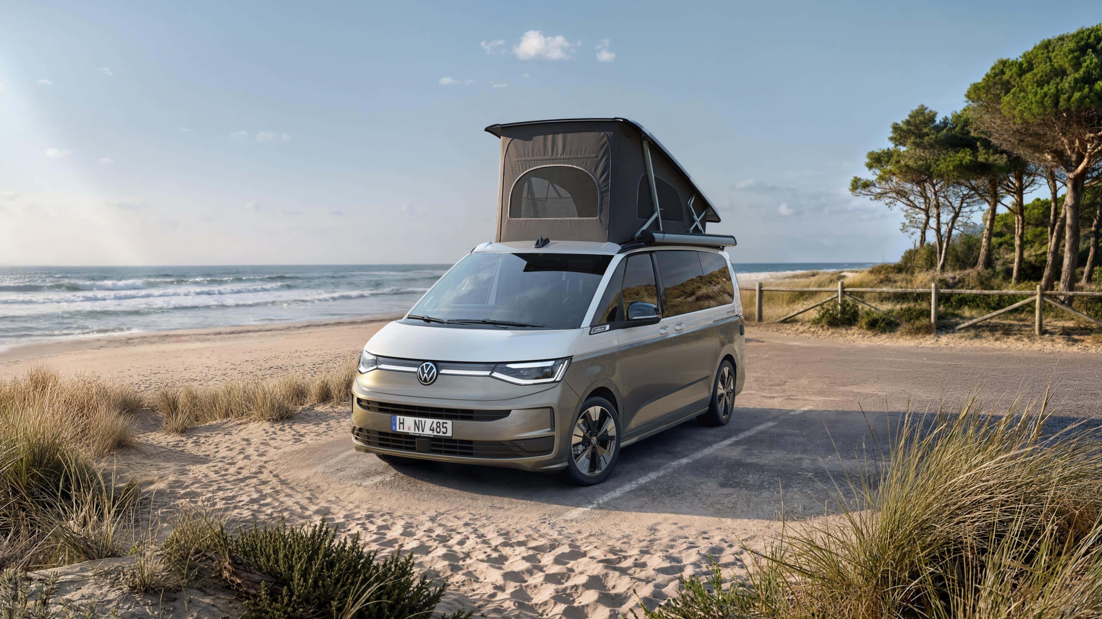 VW California com teto elevatório parada num estacionamento na praia.