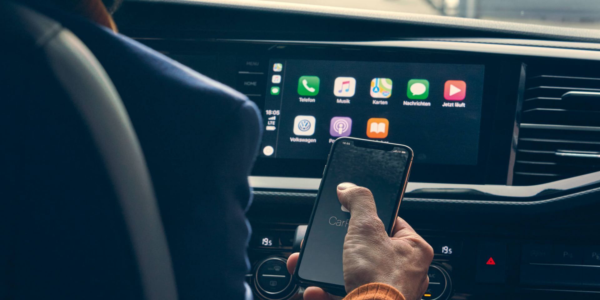 Ein Mann bedient gerade die VW We Connect App auf einem Smartphone