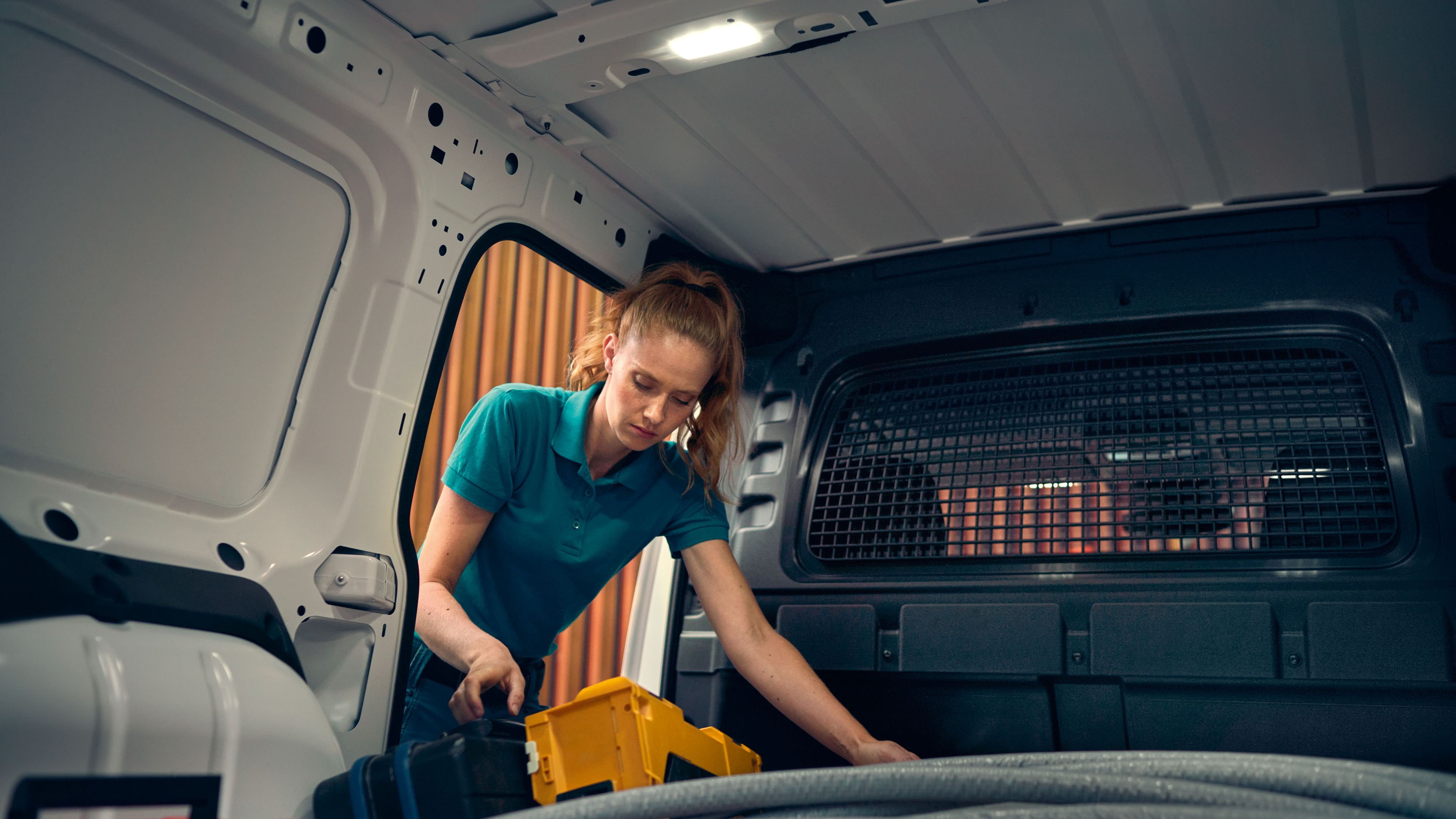 Uma mulher a carregar um branco no VW Caddy Cargo.