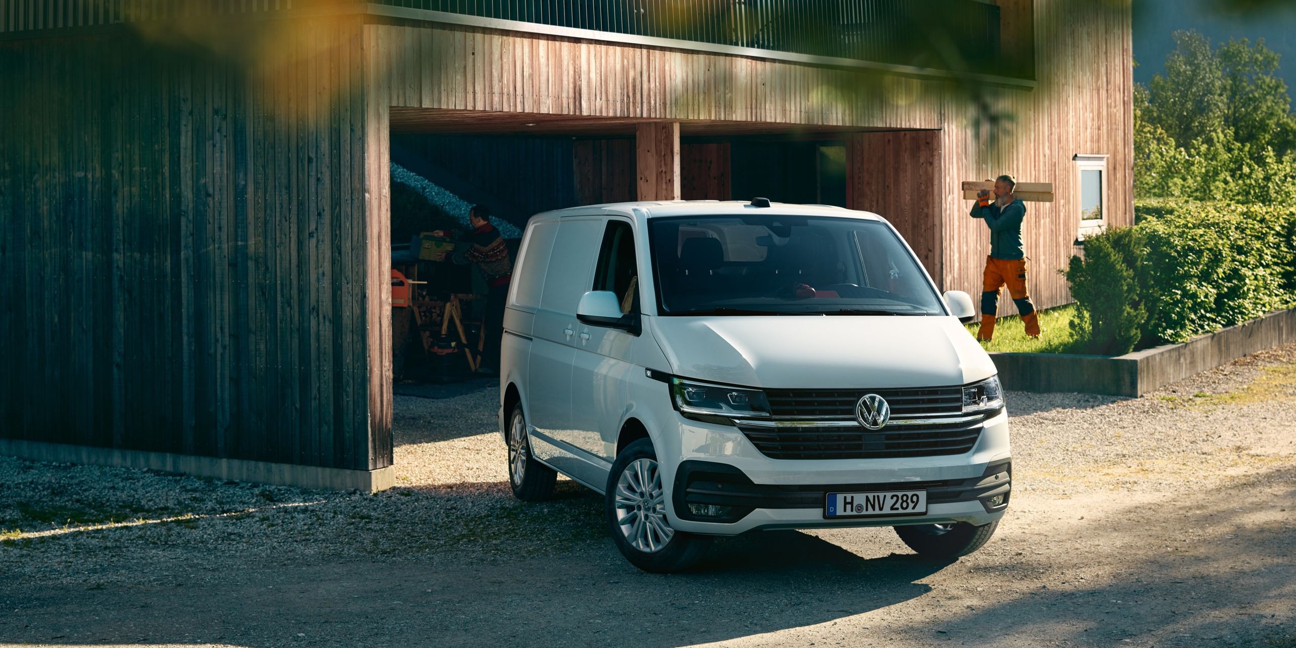 Uma carrinha Transporter 6.1 em frente a uma casa em obras.