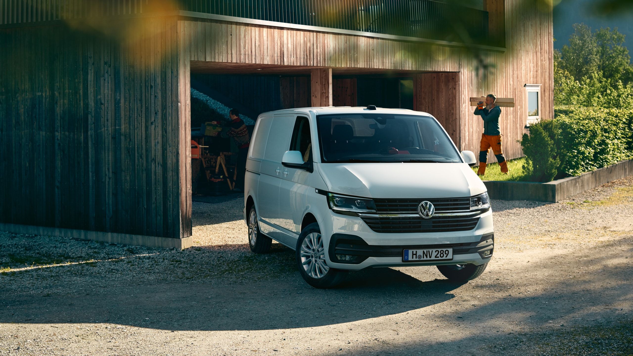 Uma carrinha Transporter 6.1 em frente a uma casa em obras.