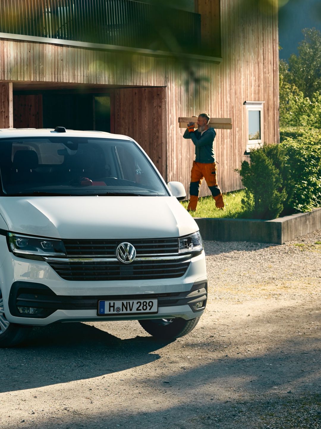 Uma carrinha Transporter 6.1 em frente a uma casa em obras.