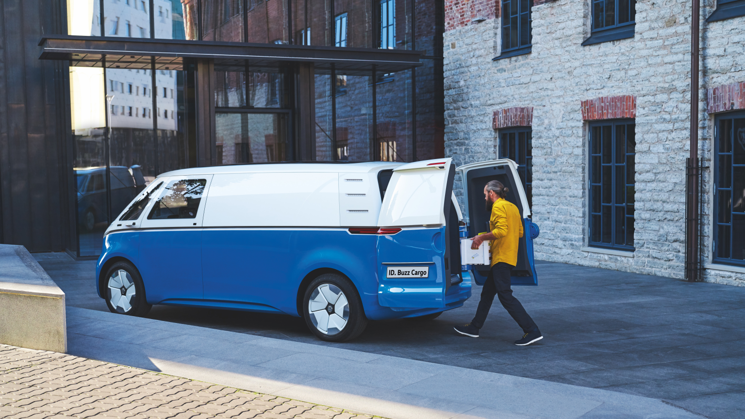 A carrinha elétrica Volkswagen e-Crafter vista de trás. Através das portas traseiras de abertura lateral abertas pode ver-se o compartimento de carga do furgão elétrico.