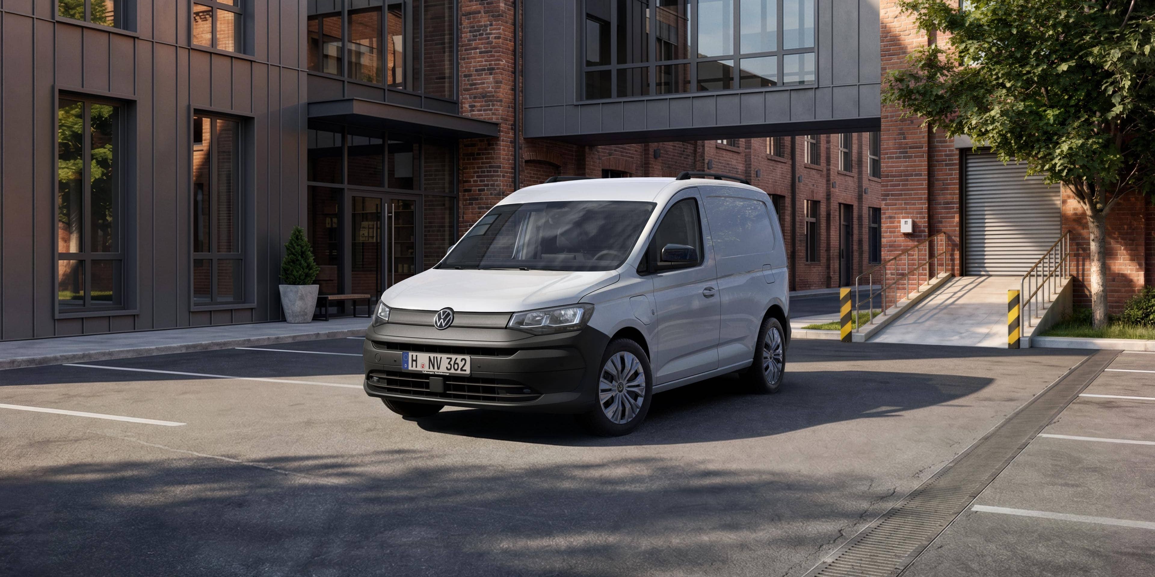 Um Volkswagen Caddy Cargo estacionada à frente de prédios.
