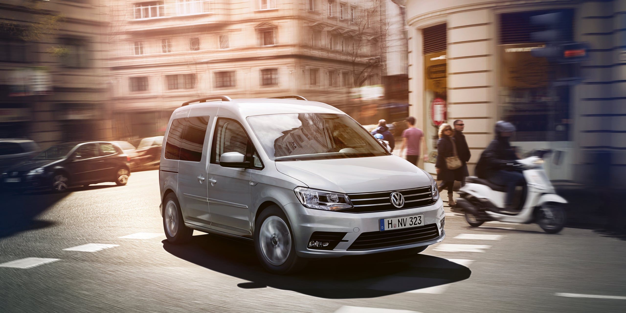 Uma VW Caddy atravessa uma estrada na cidade.