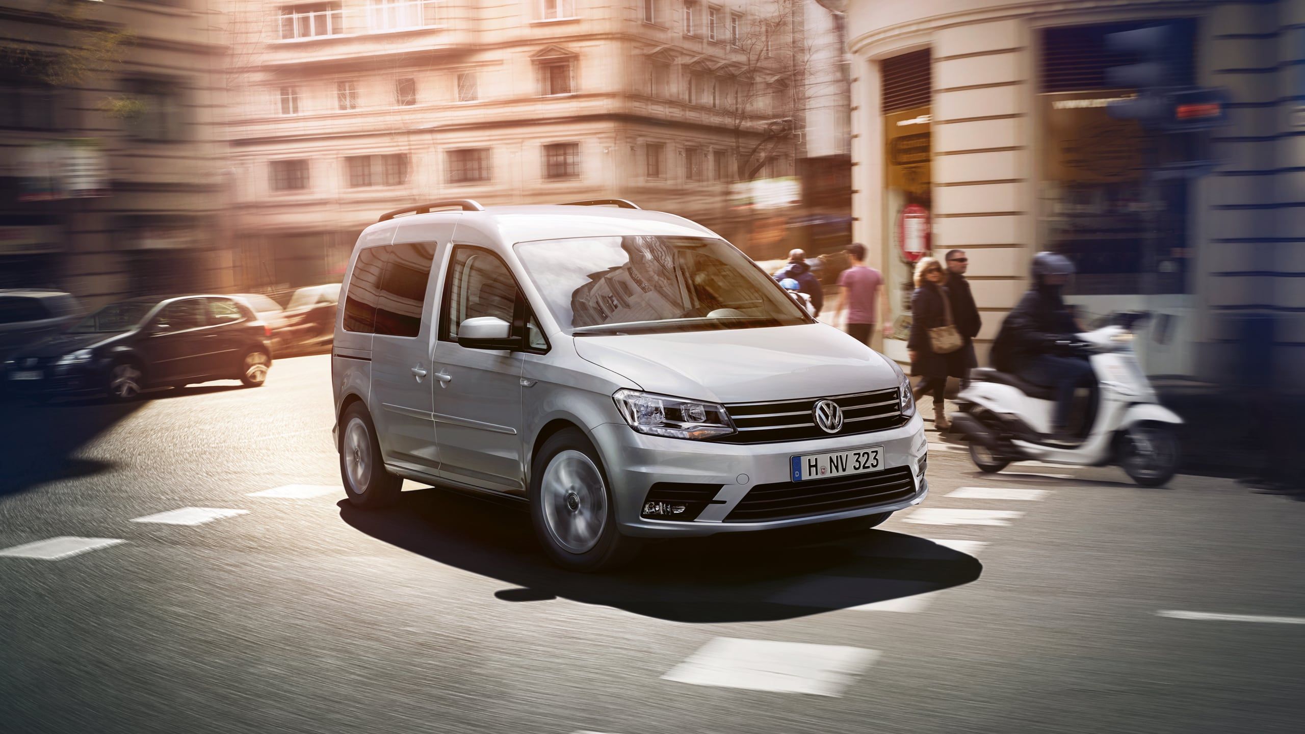 Uma VW Caddy atravessa uma estrada na cidade.