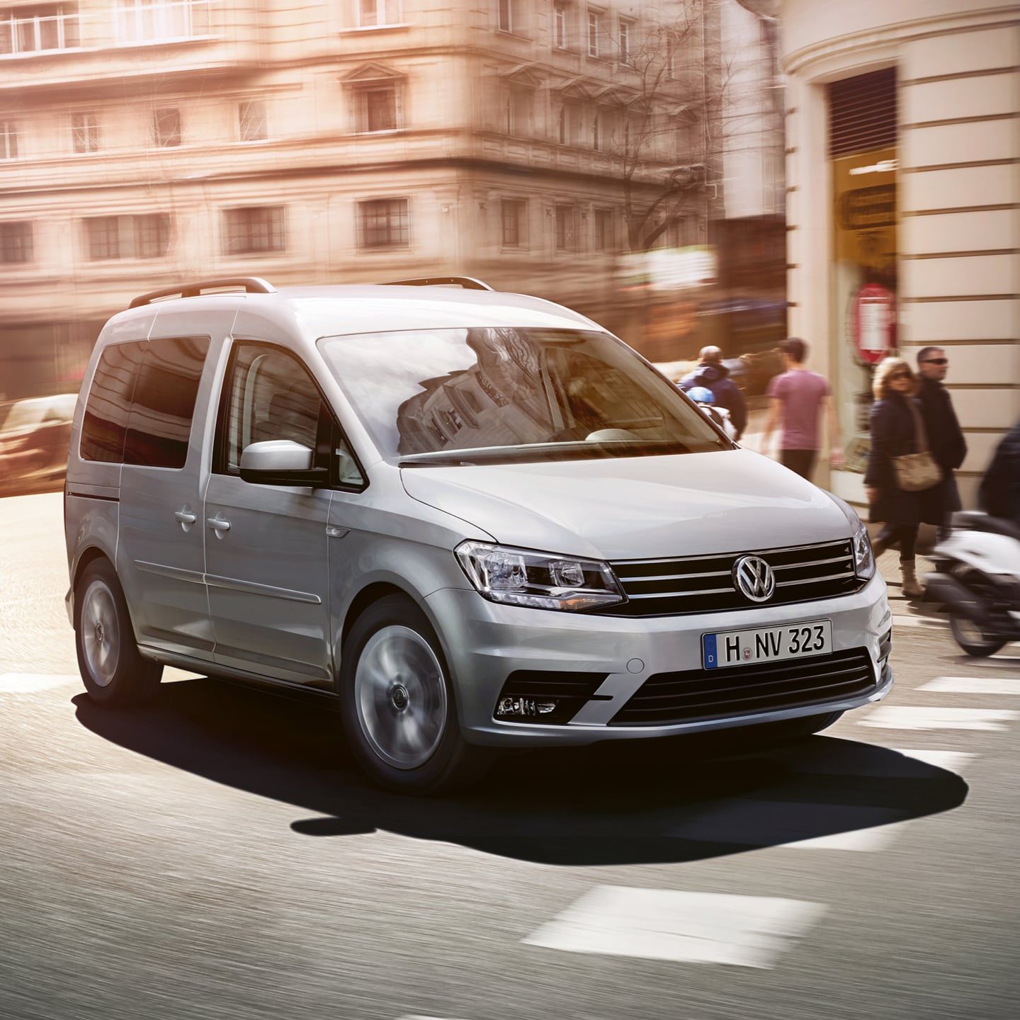 Uma VW Caddy atravessa uma estrada na cidade.