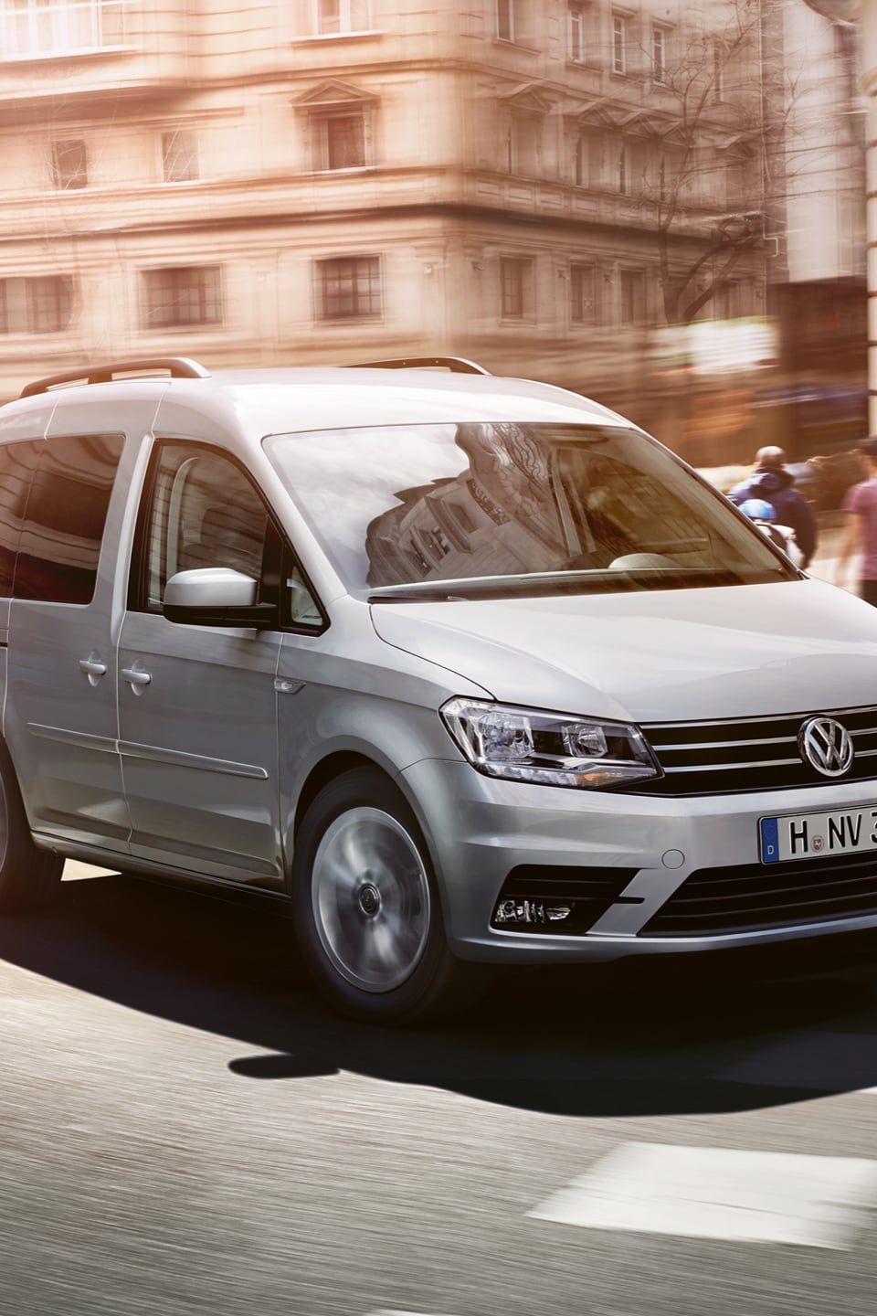 Uma VW Caddy atravessa uma estrada na cidade.