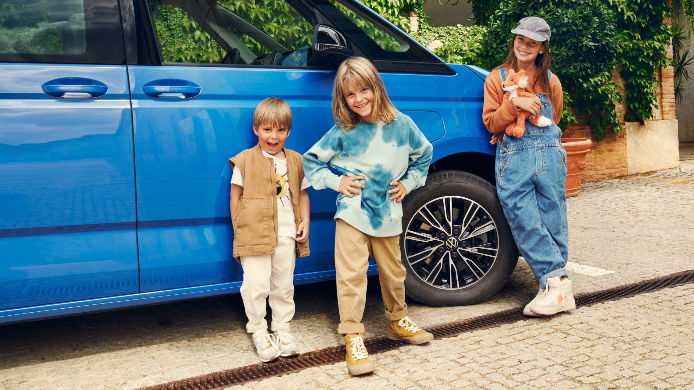 Três crianças em frente ao VW Multivan.