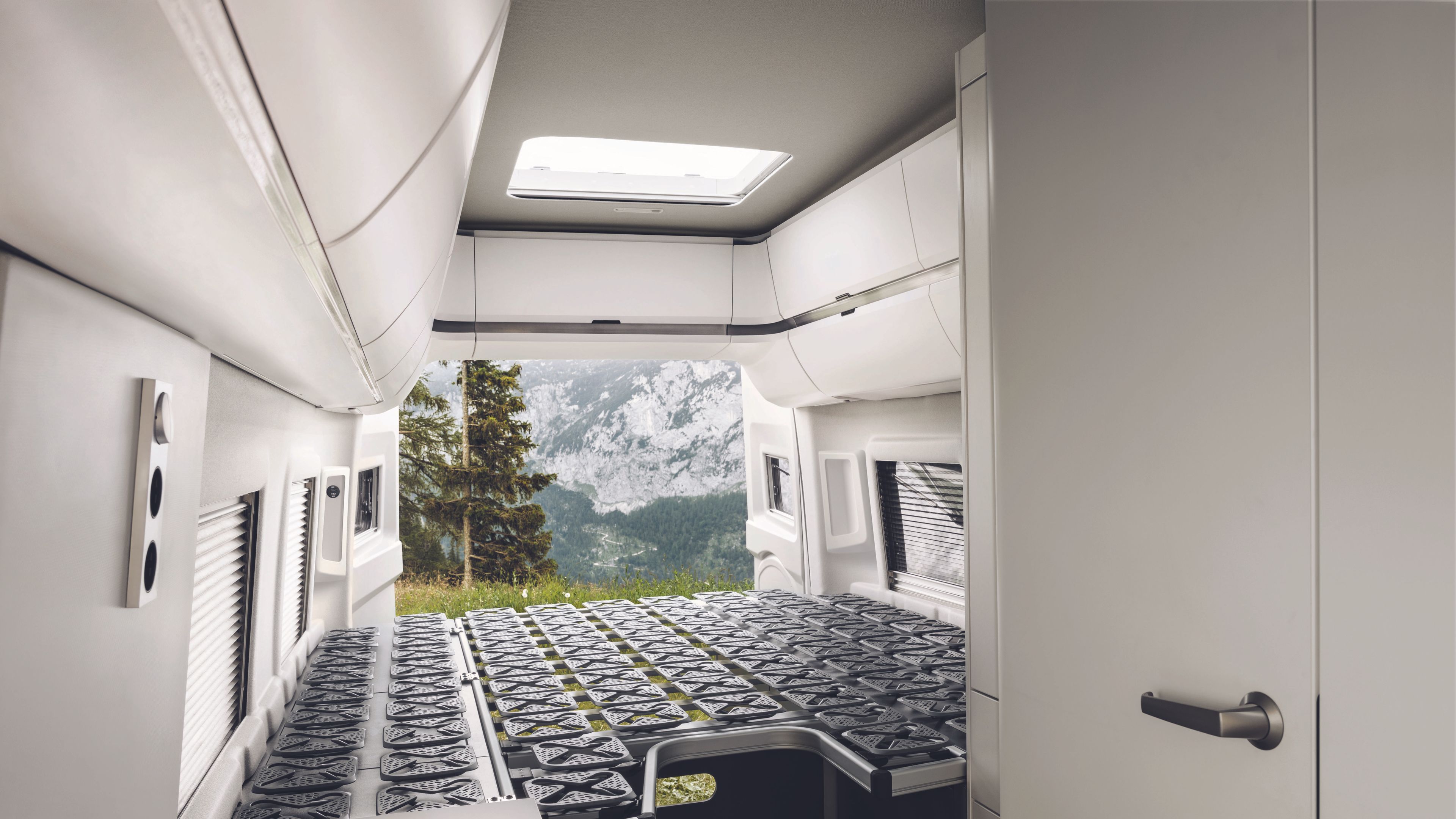 A espaçosa cama traseira da VW California 680 sem colchão. É possível ver as confortáveis molas de disco.
