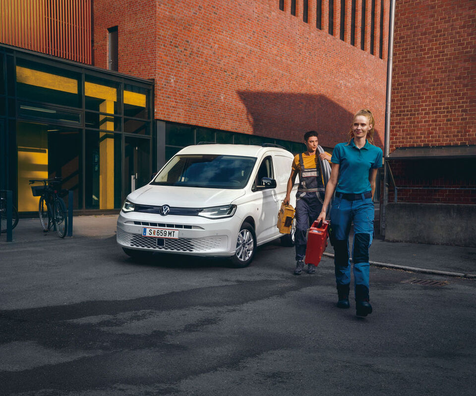 Uma equipa de operários em frente de um Caddy Cargo VW branco.
