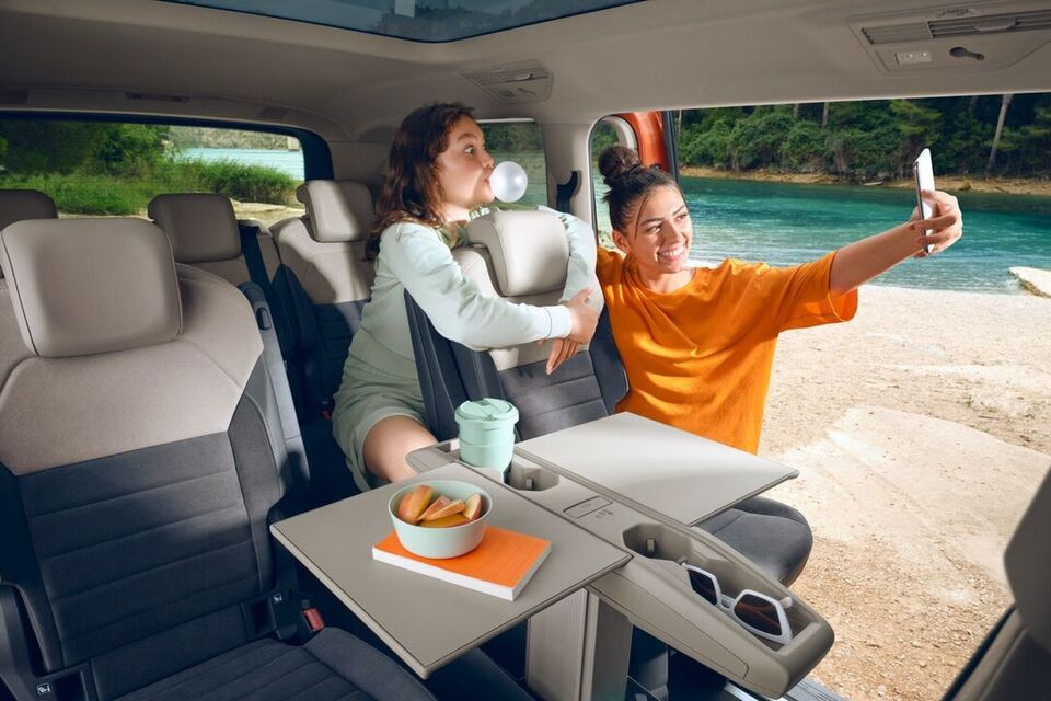 Duas raparigas tiram uma selfie dentro do VW Multivan.