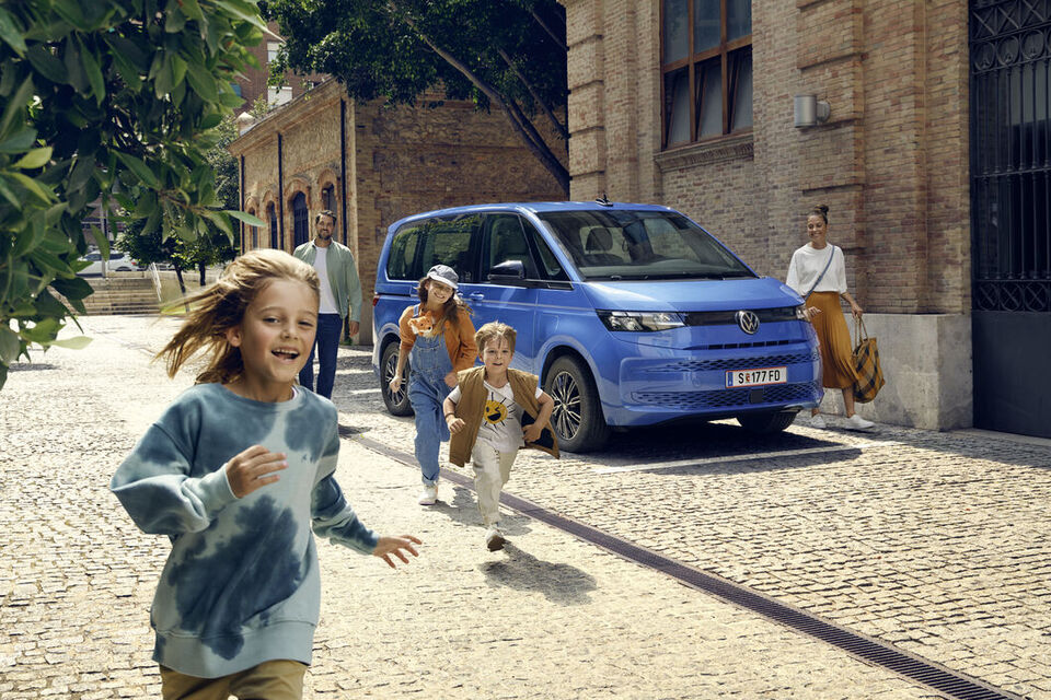 Uma família estacionou a VW Multivan na beira da estrada para um dia na cidade.