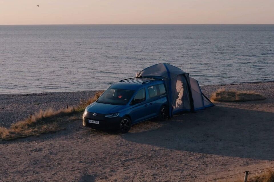 É a apresentada a mini camper VW Caddy California com tenda traseira montada numa duna.