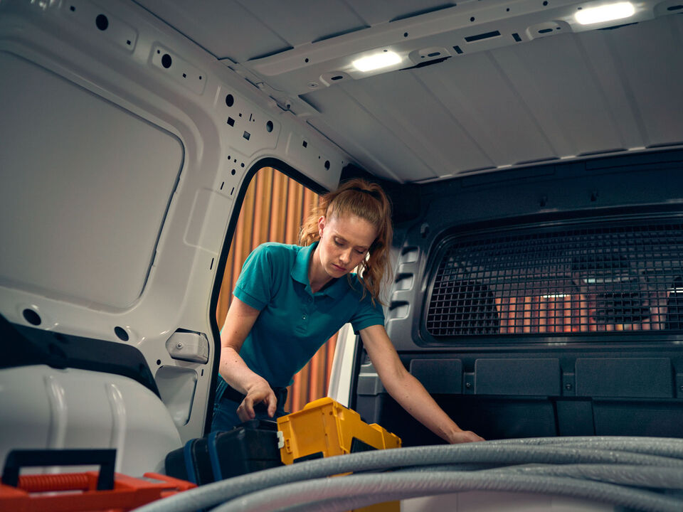 Uma mulher guarda as suas ferramentas na nova carrinha VW Caddy Cargo.