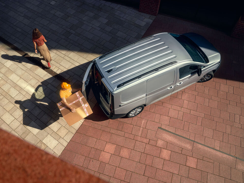 Perspetiva lateral do novo Volkswagen Caddy Cargo com a porta lateral aberta.