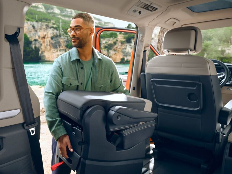 Ein Mann nimmt die flexiblen Einzelsitze des VW Multivan T7 2021 heraus.