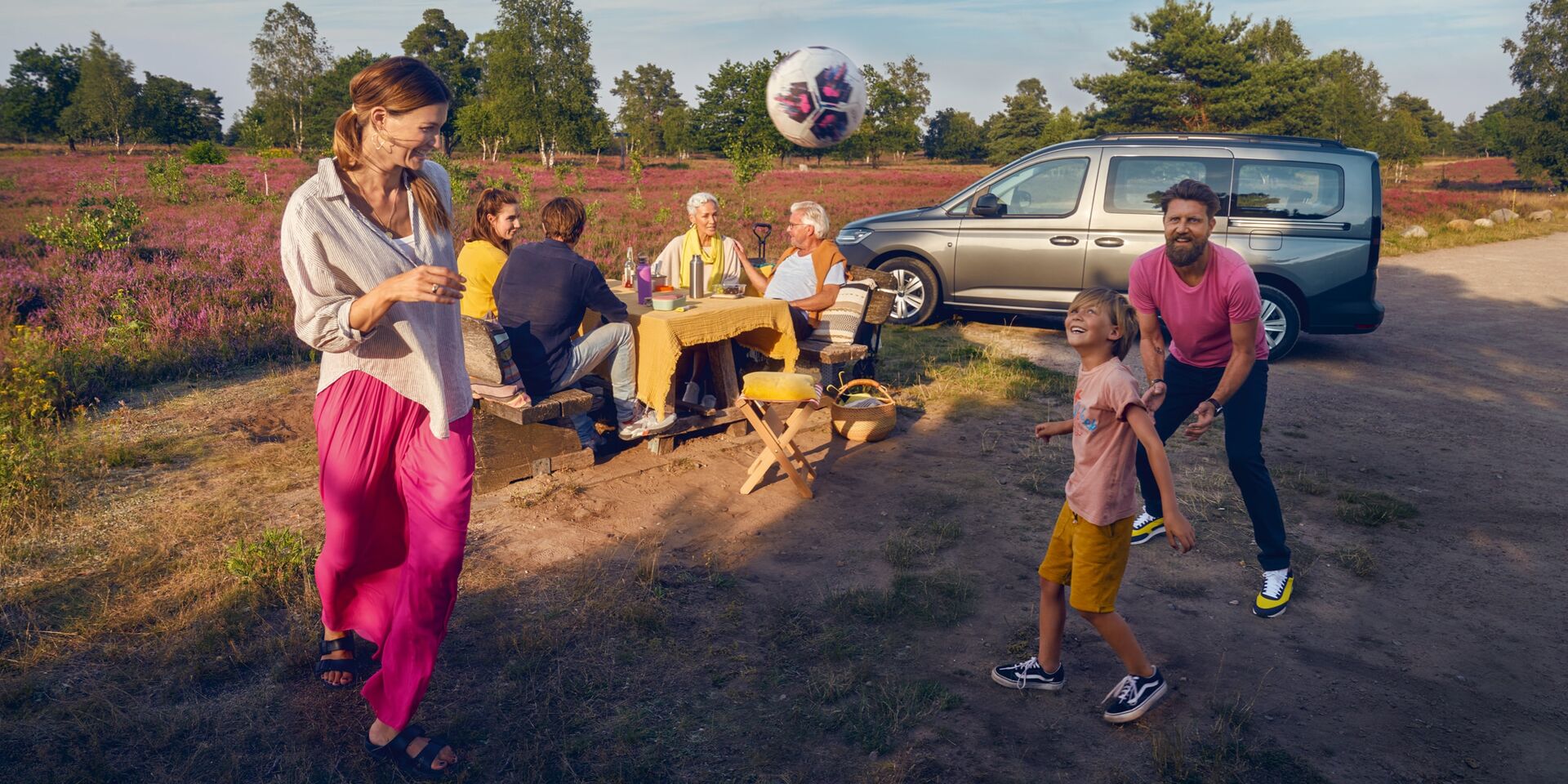Família reunida num picnic junto ao VW Caddy Maxi