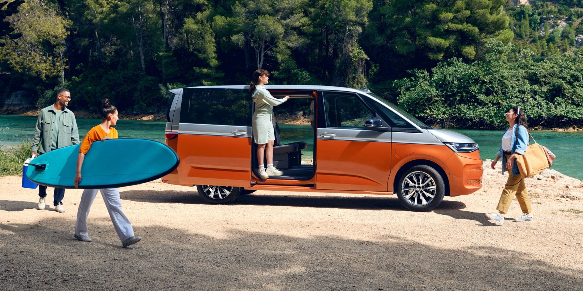 Uma família estaciona o seu VW Multivan Energetic numa praia fluvial.