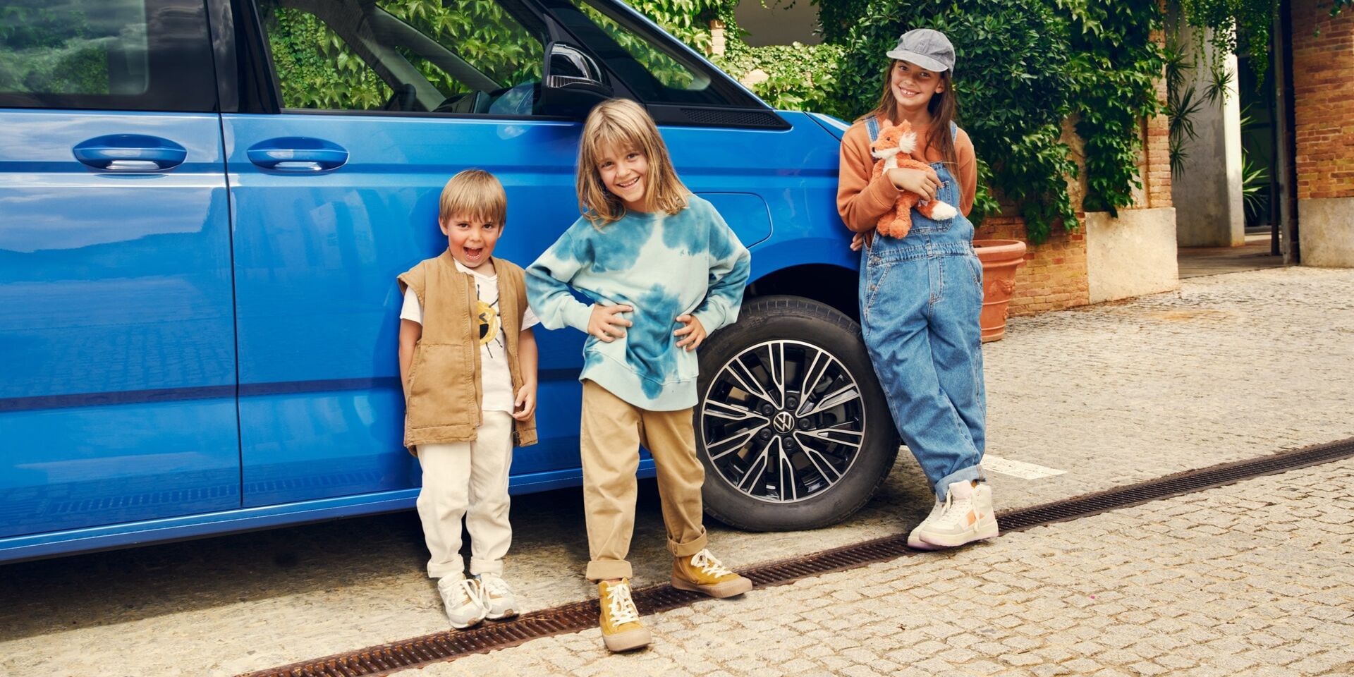 Três crianças em frente ao VW Multivan.