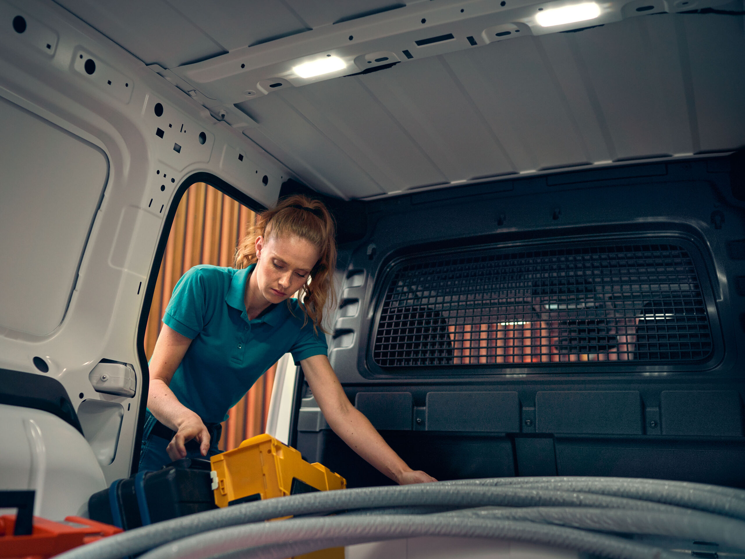 Uma mulher guarda as suas ferramentas na nova carrinha VW Caddy Cargo.