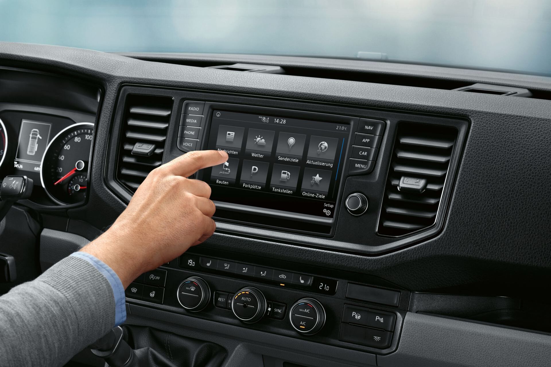 Na cabina do condutor da VW Crafter parada. No fundo pode ver-se o serviço online Car-Net no ecrã multifunções.