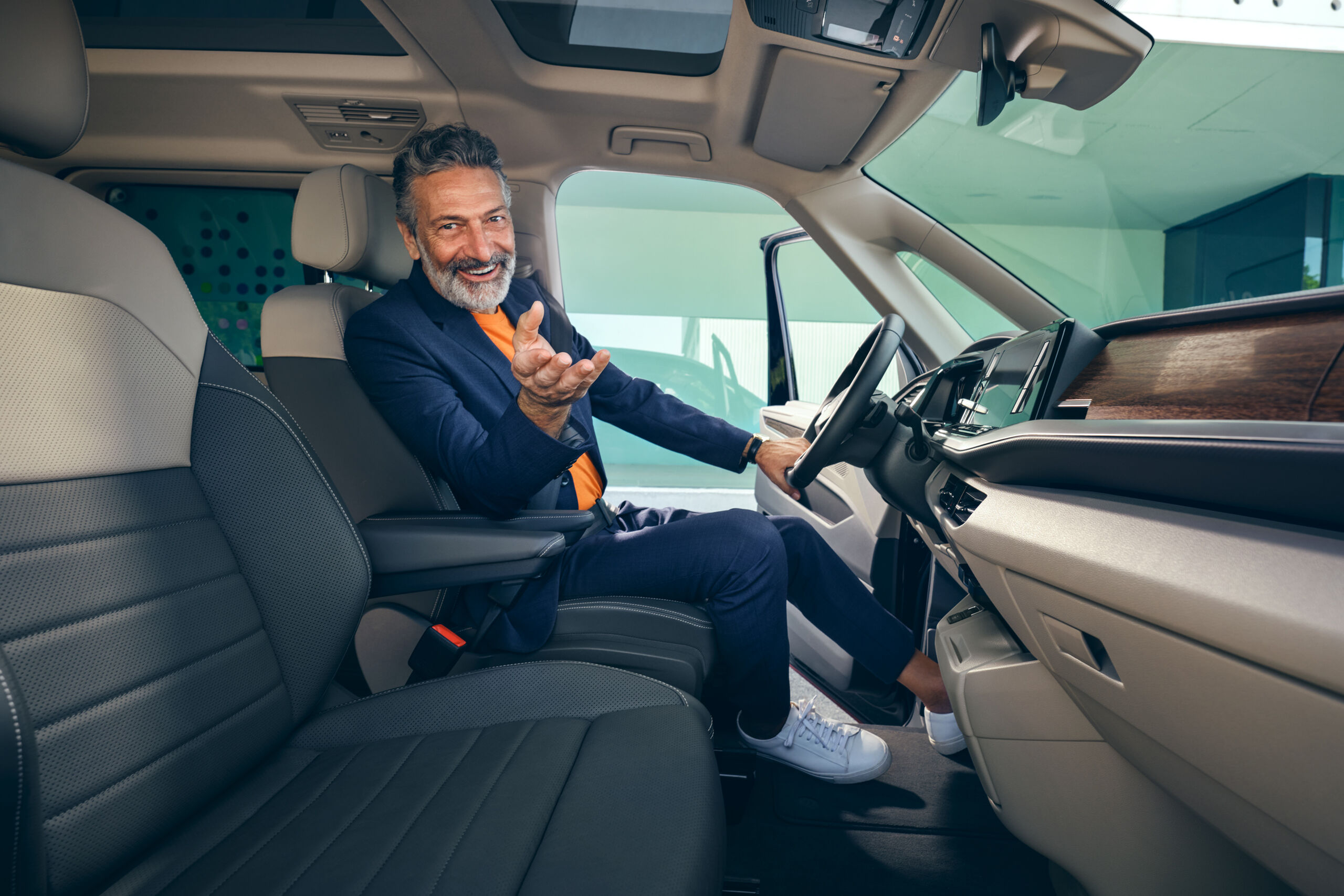 Ein Mann sitzt auf dem Fahrersitz im neuen VW Multivan T7 2021 Style.