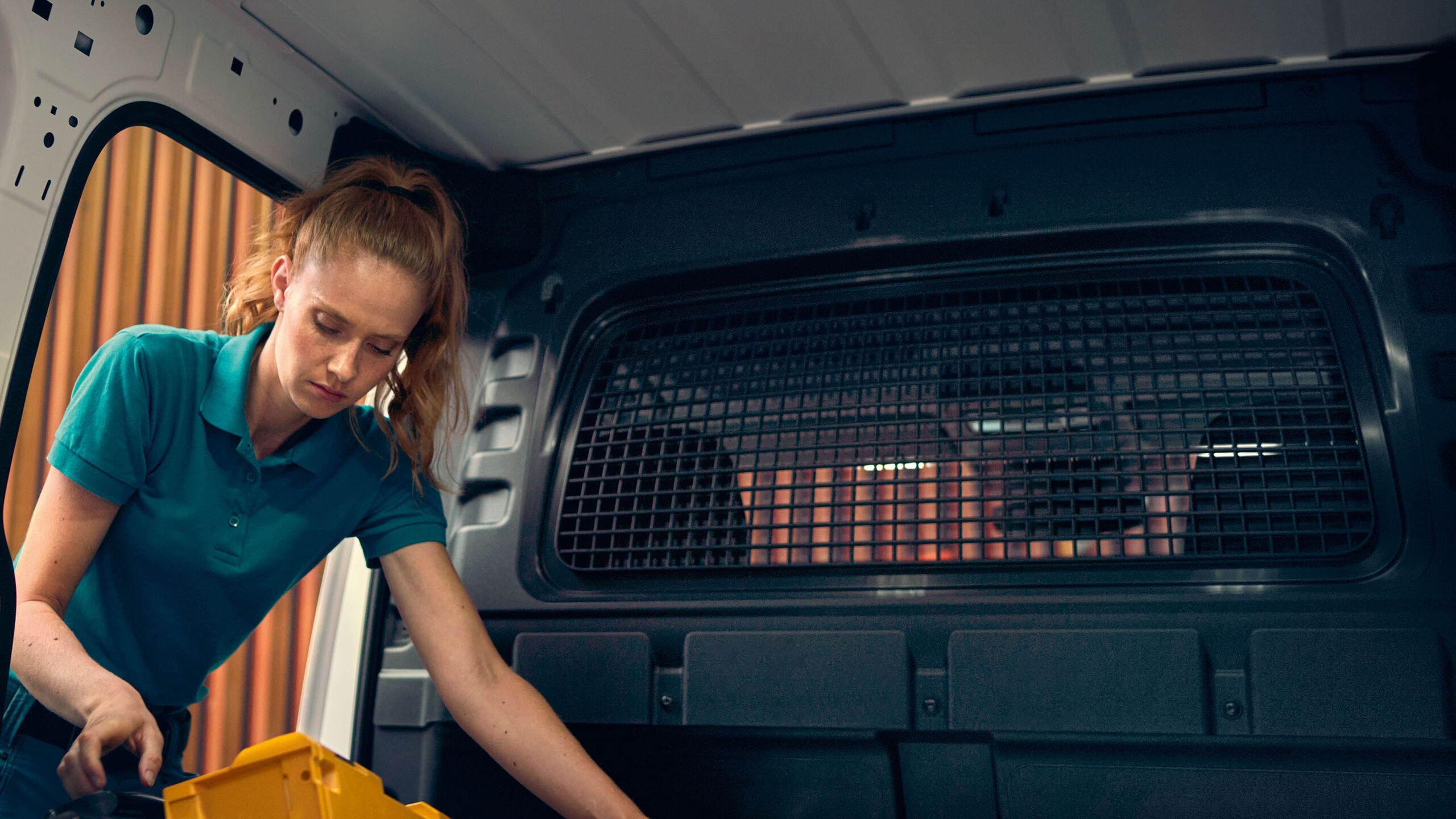 Uma mulher a carregar um branco no VW Caddy Cargo.