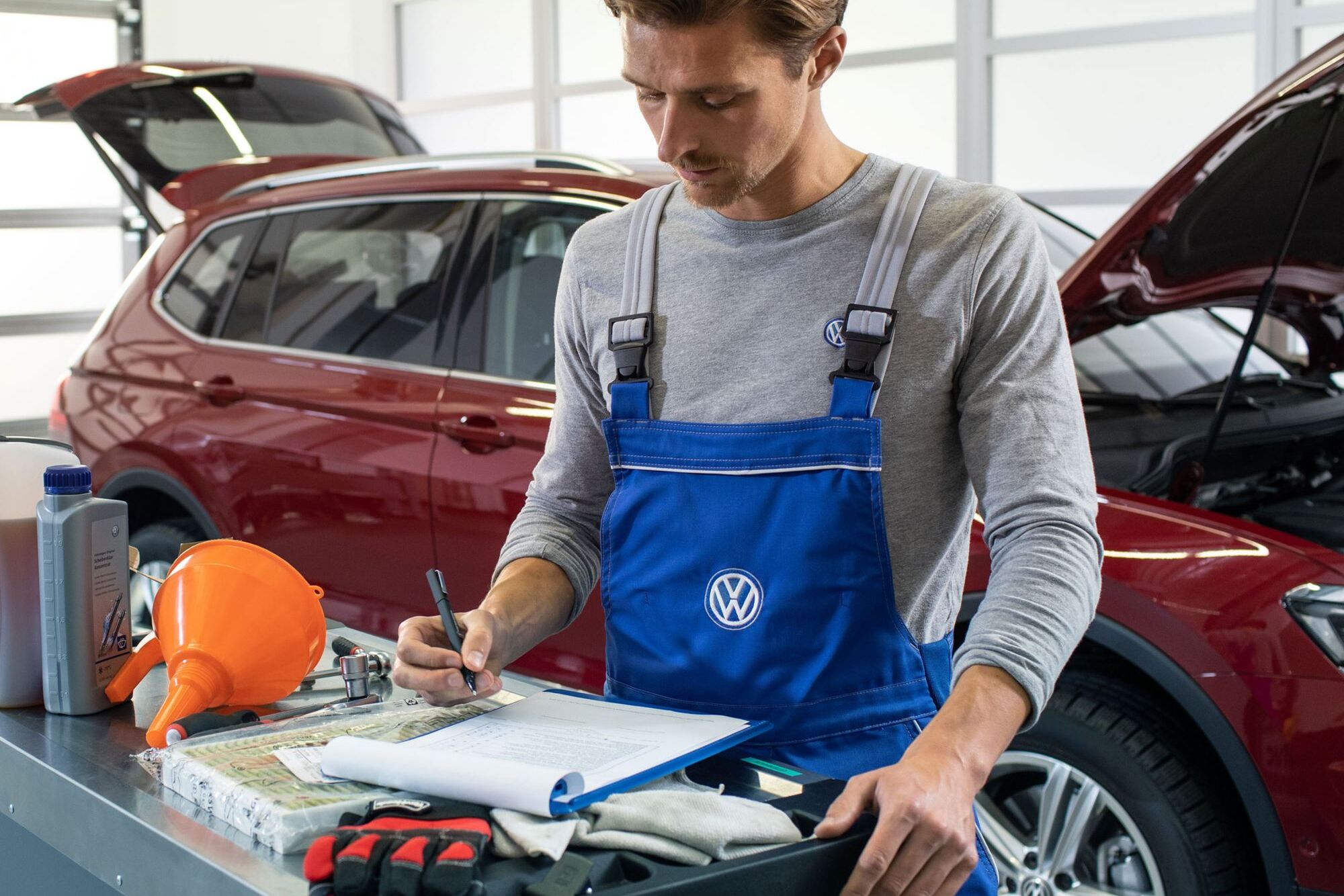 Empregado de serviço da VW verifica um carro com condução a gás natural numa oficina