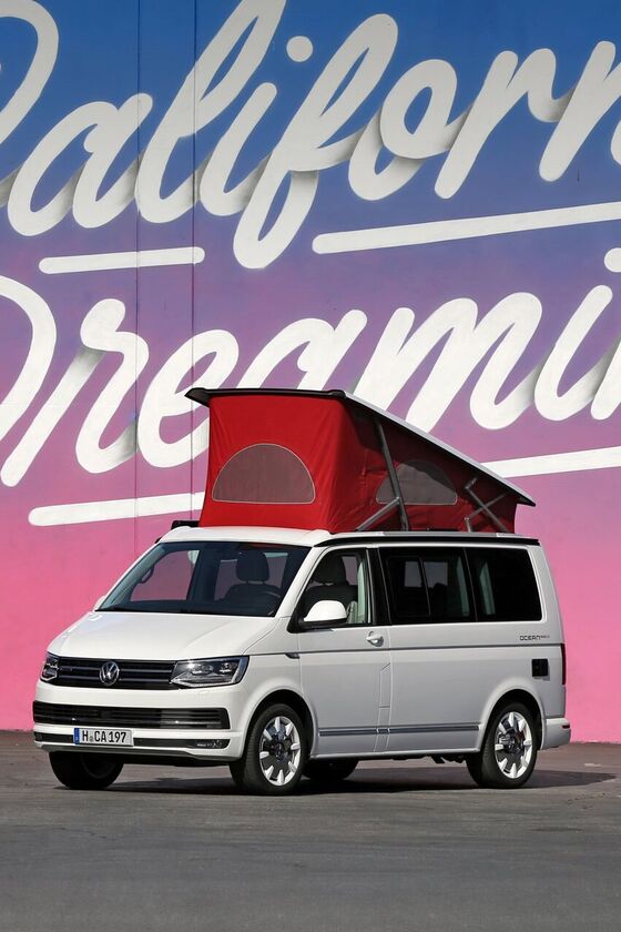 Uma Volkswagen California com telhado elevado está à frente da inscrição ilustrada "California Dreaming".