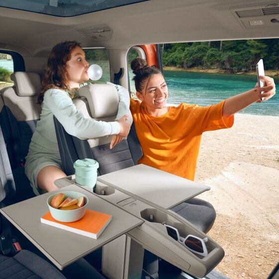 Duas raparigas tiram uma selfie dentro do VW Multivan.
