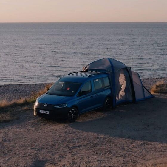 É a apresentada a mini camper VW Caddy California com tenda traseira montada numa duna.