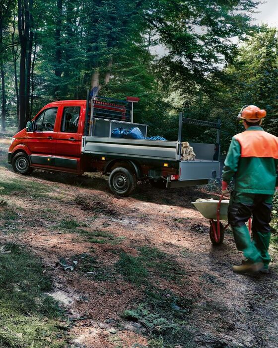 Uma VW Crafter Furgão desloca-se de forma dinâmica num caminho de floresta.