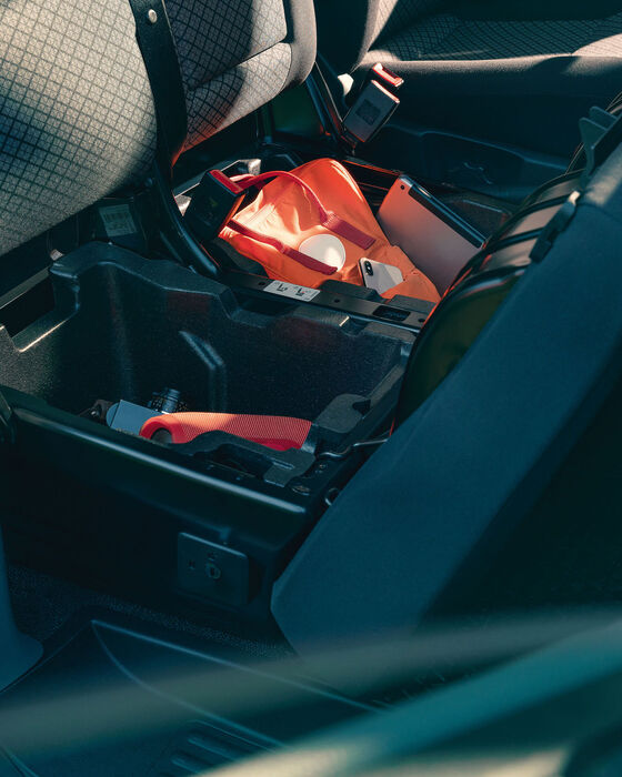 Caixas de arrumação por baixo do duplo assento na kombi Volkswagen Caravelle.