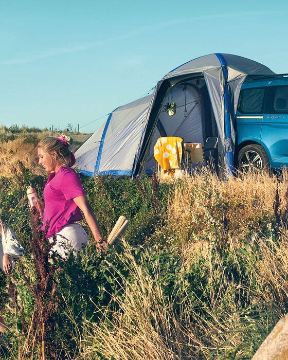 VW Caddy California equipada com uma tenda numa duna.