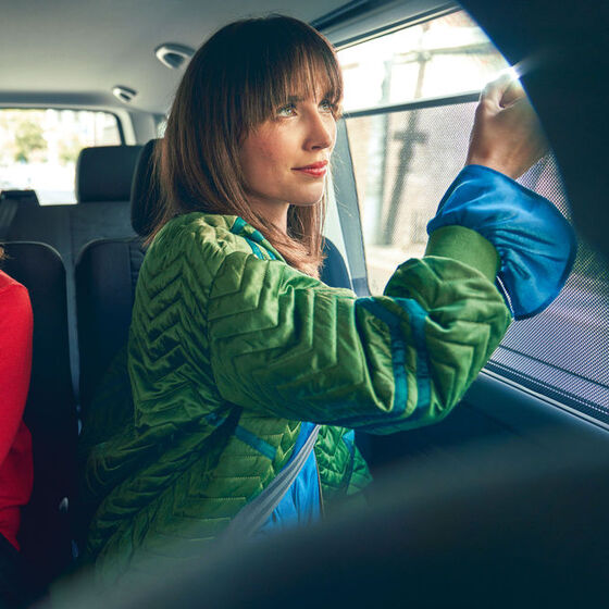 Duas mulheres sentadas nos bancos traseiros da VW Caravelle 6.1.