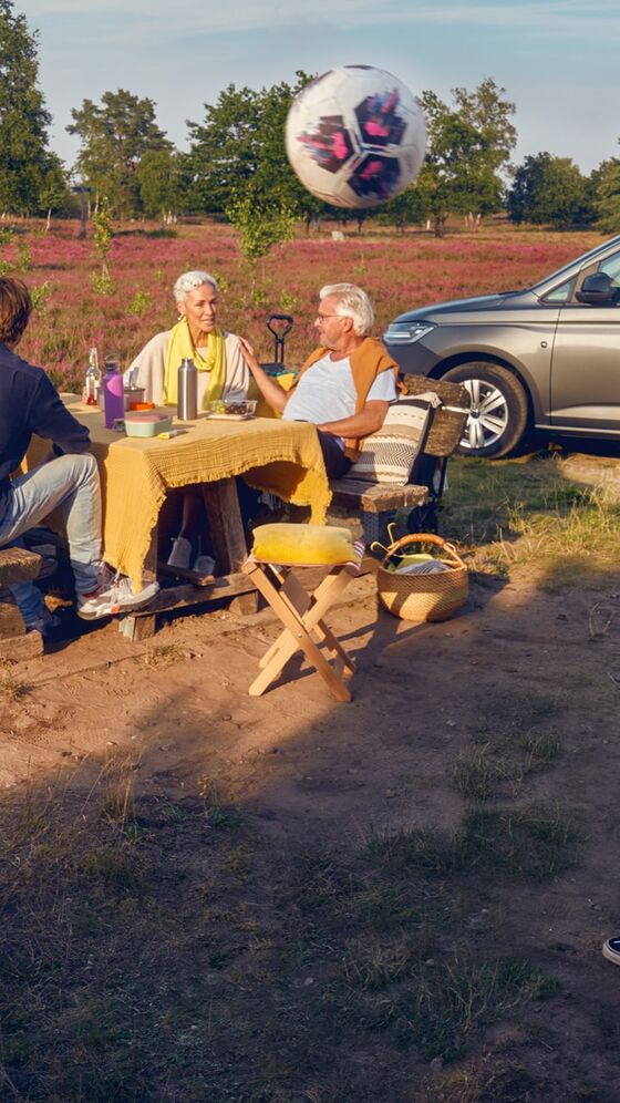 Família reunida num picnic junto ao VW Caddy Maxi