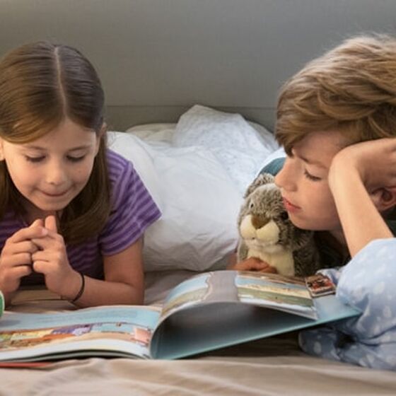 Um rapazinho e a sua irmã a lerem juntos um livro, na cama alta da Grand California.