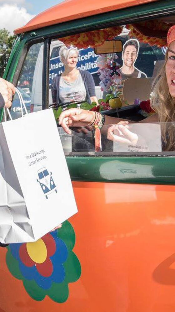 Uma senhora a entregar um saco com comida aos condutores das Pão de Forma
