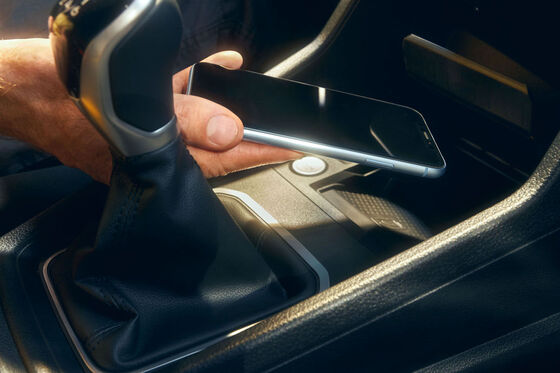 O smartphone é colocado na interface do telemóvel do VW Caddy Cargo para carregamento.