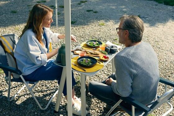 Um casal desfruta de uma refeição numa mesa de campismo 
