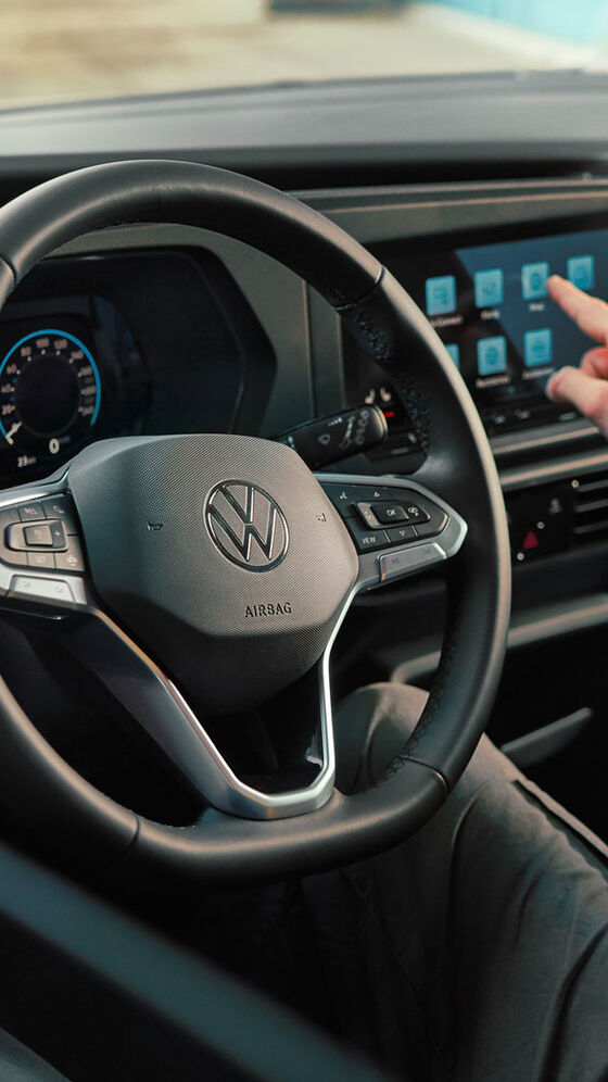Homem a mexer na interface de navegação do VW Caddy