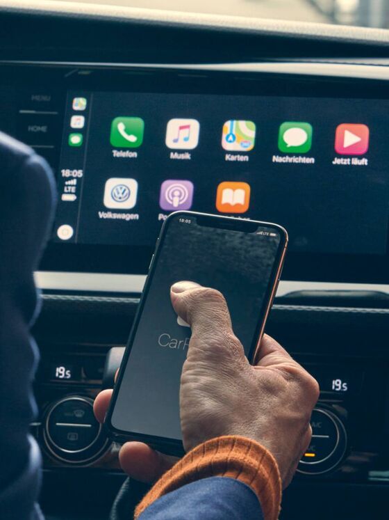 Ein Mann bedient gerade die VW We Connect App auf einem Smartphone