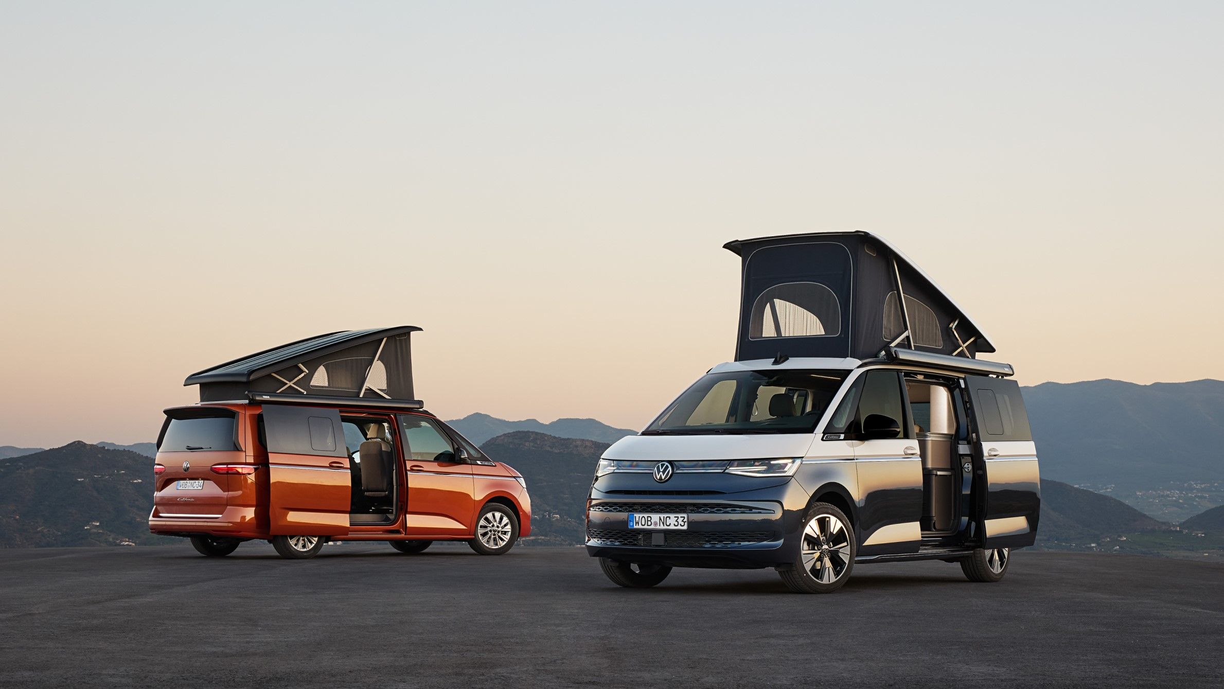 Dois veículos Volkswagen California, ambos com o teto elevado e portas abertas.